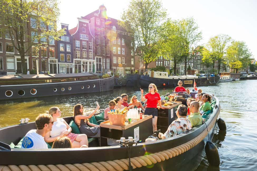 Amsterdam: Guided Open Boat Canal Cruise Including Drink - The guide experience: history, culture, and quick storytelling